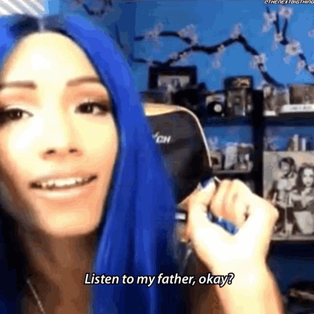 a woman with blue hair is holding a cell phone and saying listen to my father okay ?