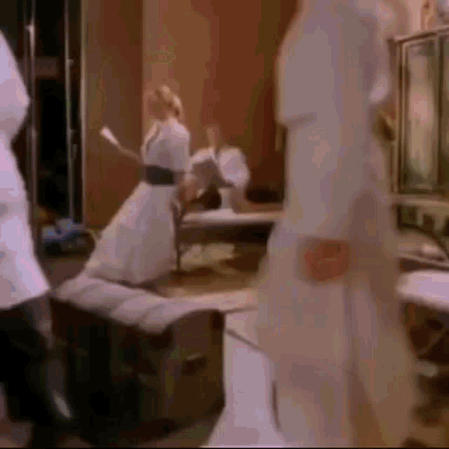 a woman in a white dress is dancing in a room