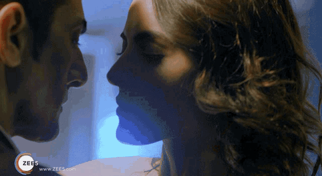 a close up of a man and woman kissing with a zee5 logo in the background
