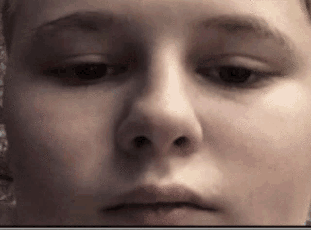 a close up of a woman 's face with a slight smile on her face