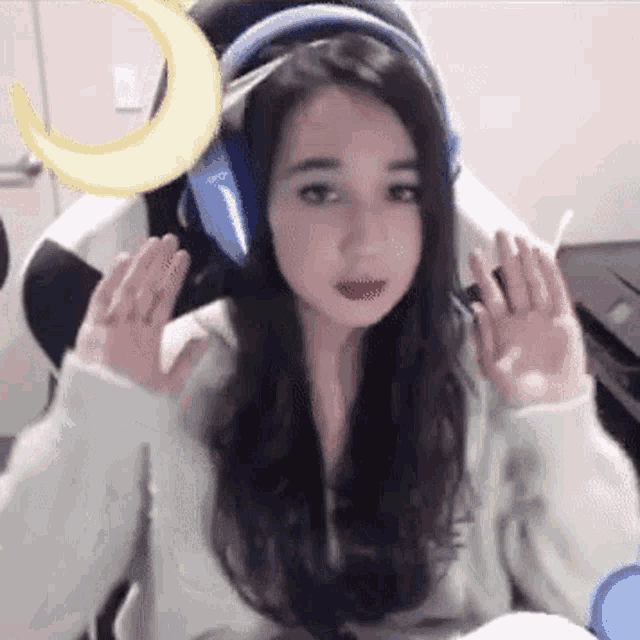 a young woman wearing headphones is sitting in a chair .