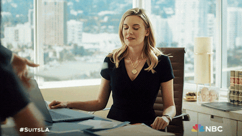a woman sits at a desk with a laptop and a nbc logo on the bottom