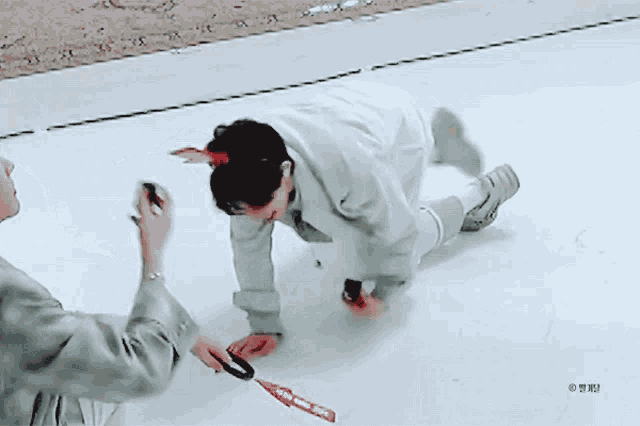 a person is kneeling down in the snow while another person takes a picture of him