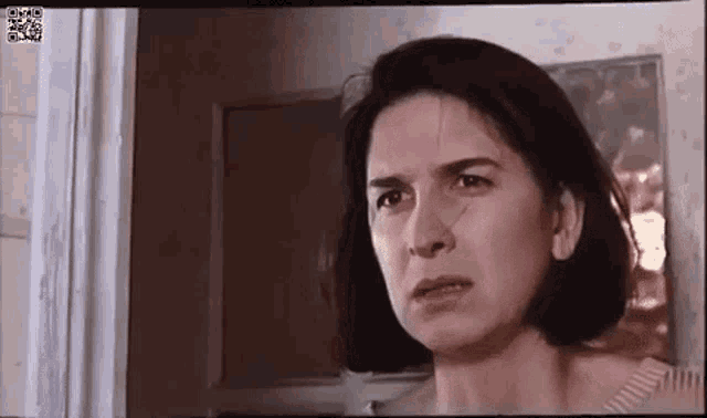 a woman is making a funny face while looking at the camera .
