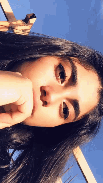 a close up of a woman 's face with her hand on her mouth