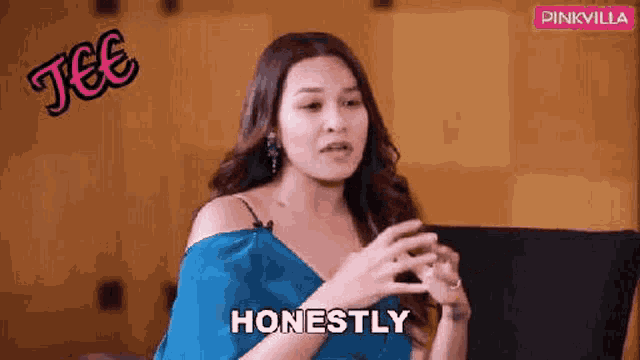 a woman in a blue dress is sitting on a couch talking to someone and saying `` honestly '' .