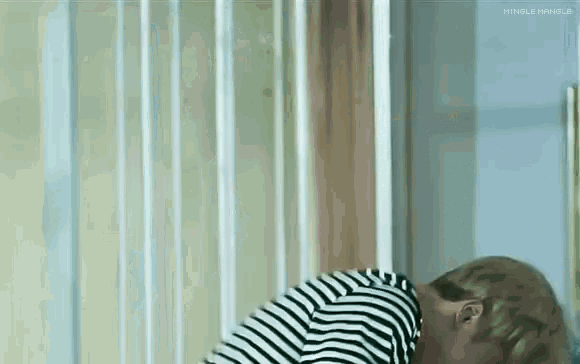 a man in a striped shirt is laying down in a room with his head on the floor .