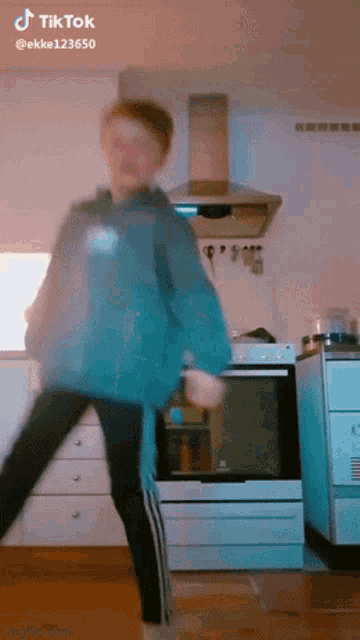 a person is dancing in a kitchen and their tiktok is ekke123650