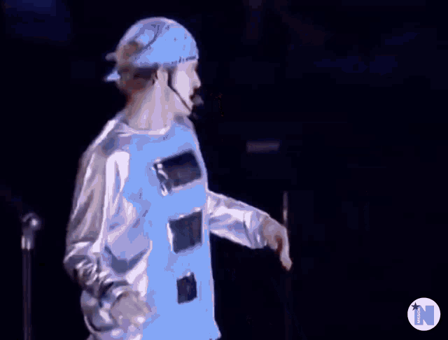 a man wearing a bandana is dancing on a stage .
