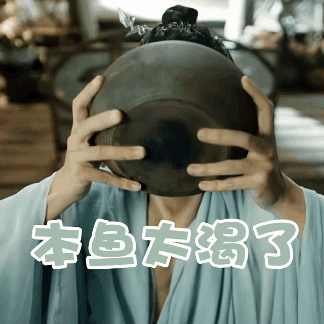a person is holding a bowl in front of their face with chinese writing below it