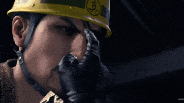 a man wearing a yellow hard hat has chinese characters on it