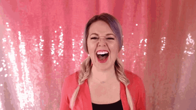 a woman with purple hair is laughing with her mouth open