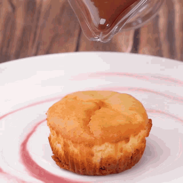 a cupcake on a white plate with a pink swirl
