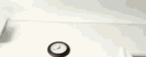 a clock is hanging on a wall in a room with a white ceiling .