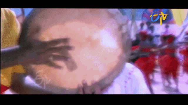 a tv screen shows a group of people playing drums