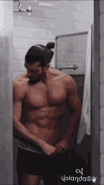 a shirtless man with a ponytail is standing in a bathroom with the words cu yolanda on the bottom