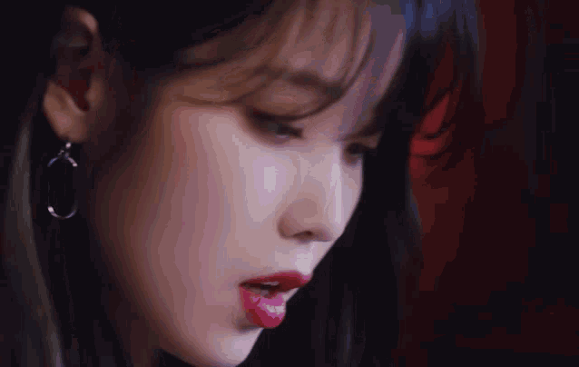 a close up of a woman 's face with red lipstick on her lips