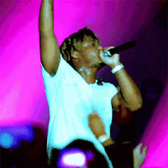 a man singing into a microphone in front of a crowd