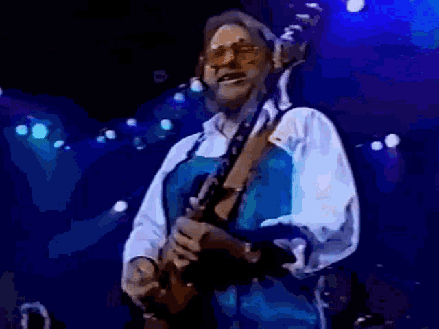 a man with a beard is playing a guitar on stage