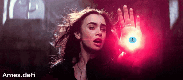 a woman is holding a red light in her hand and the words ames.defi are on the bottom