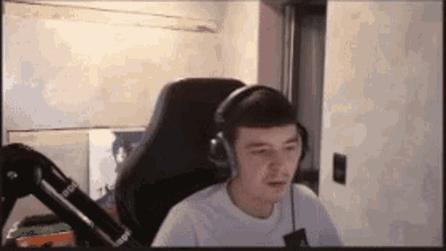 a man is wearing headphones while sitting in a chair .