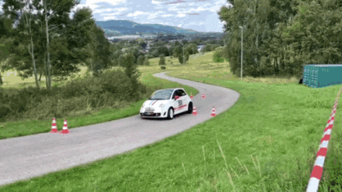 a white car with red stripes on the side is driving on a road