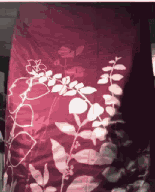 a red blanket with white flowers on it