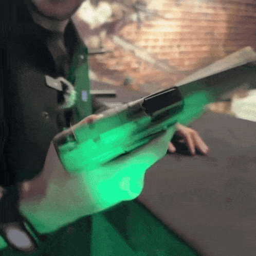 a person is holding a green lighted object in their hand