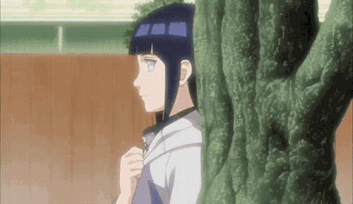 a girl is peeking out from behind a tree trunk