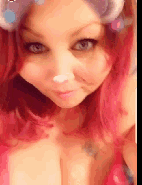 a woman with pink hair is wearing a cat ear filter