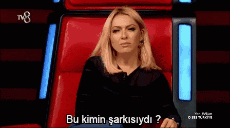 a woman is sitting in a red chair with the words bu kimin sarkisiydi written below her