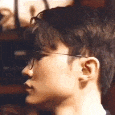 a close up of a person wearing glasses and a black shirt .