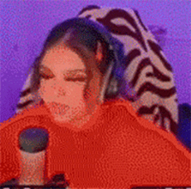 a woman wearing headphones and a red sweater is laying on a couch .