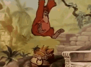 a cartoon monkey is hanging upside down from a tree