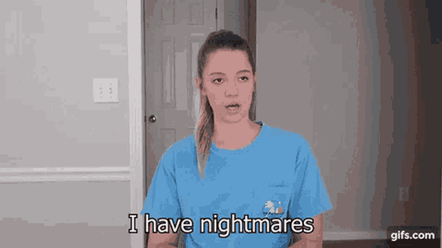 a woman in a blue t-shirt is standing in front of a door and says i have nightmares .