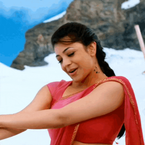 a woman in a pink crop top is dancing in the snow