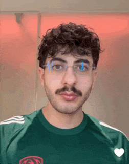 a man with glasses and a mustache is wearing a green shirt with a heart on it
