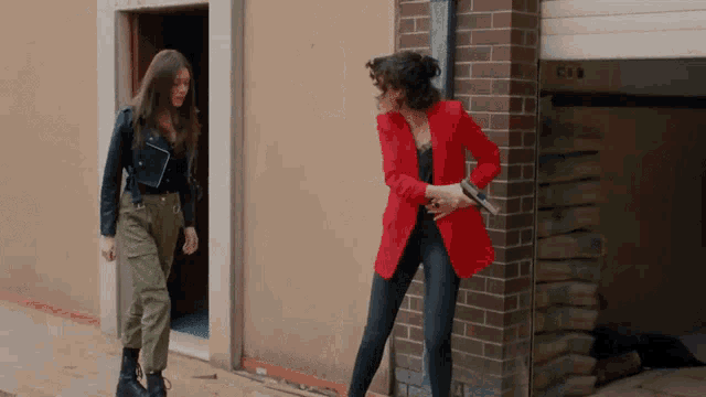 a woman in a red jacket holds a gun