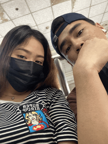 a man and a woman wearing face masks are posing for a picture together