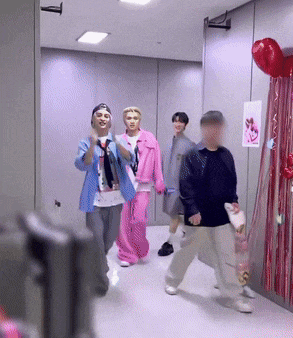 a group of people walking down a hallway with balloons