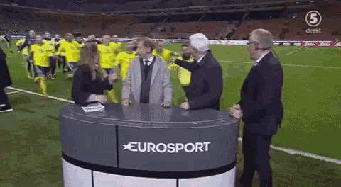 a group of people are standing around a table that says eurosport on it