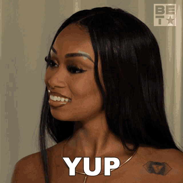 a woman is smiling and the word yup is on her neck