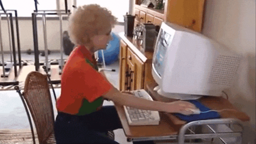 a woman is sitting at a desk in front of a computer monitor