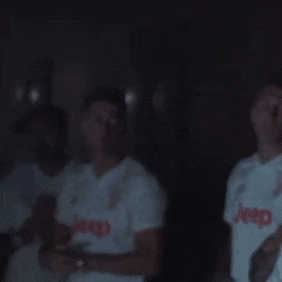 a man wearing a white jeep shirt is standing in the dark