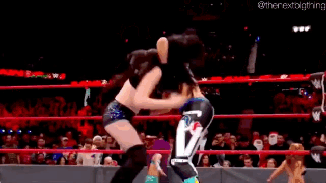 a woman is wrestling another woman in a ring .