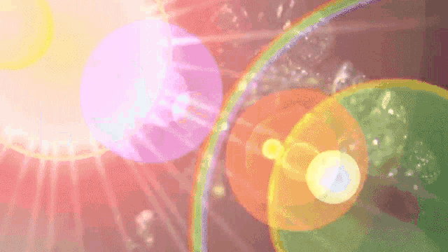 the sun shines through a rainbow and a purple circle