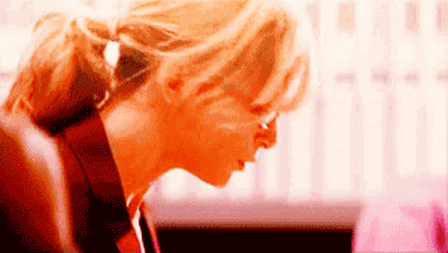 a woman with blonde hair is looking down at something