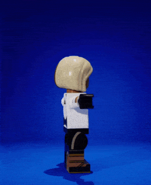 a lego figure with a white shirt and tie stands on a blue surface