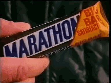 a hand is holding a marathon big bar