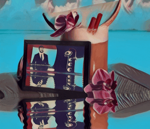 a framed picture of a man in a suit is next to a glass of a drink